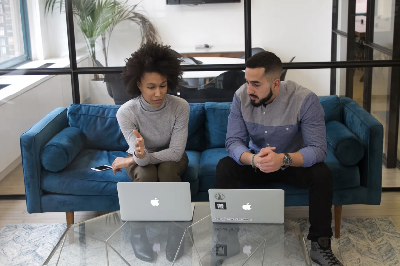 An employee explains their work to an intern